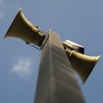 A close up of two large speakers on a pole