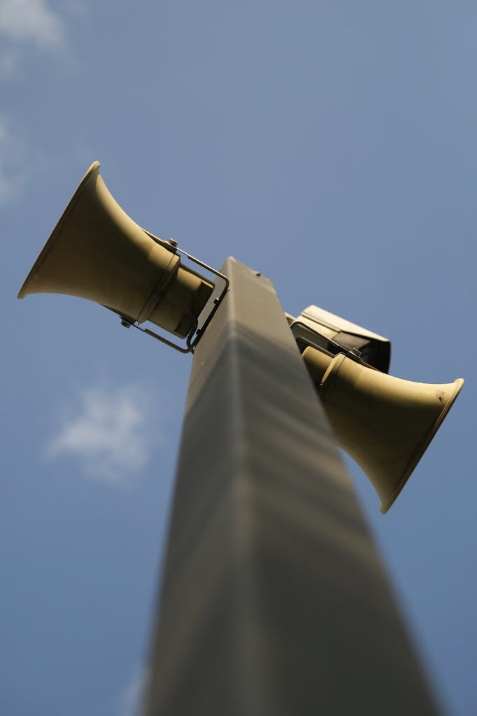 A close up of two large speakers on a pole